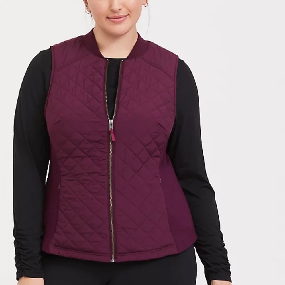 Never worn burgundy puffer zip vest with stretchy side panels and zip pockets